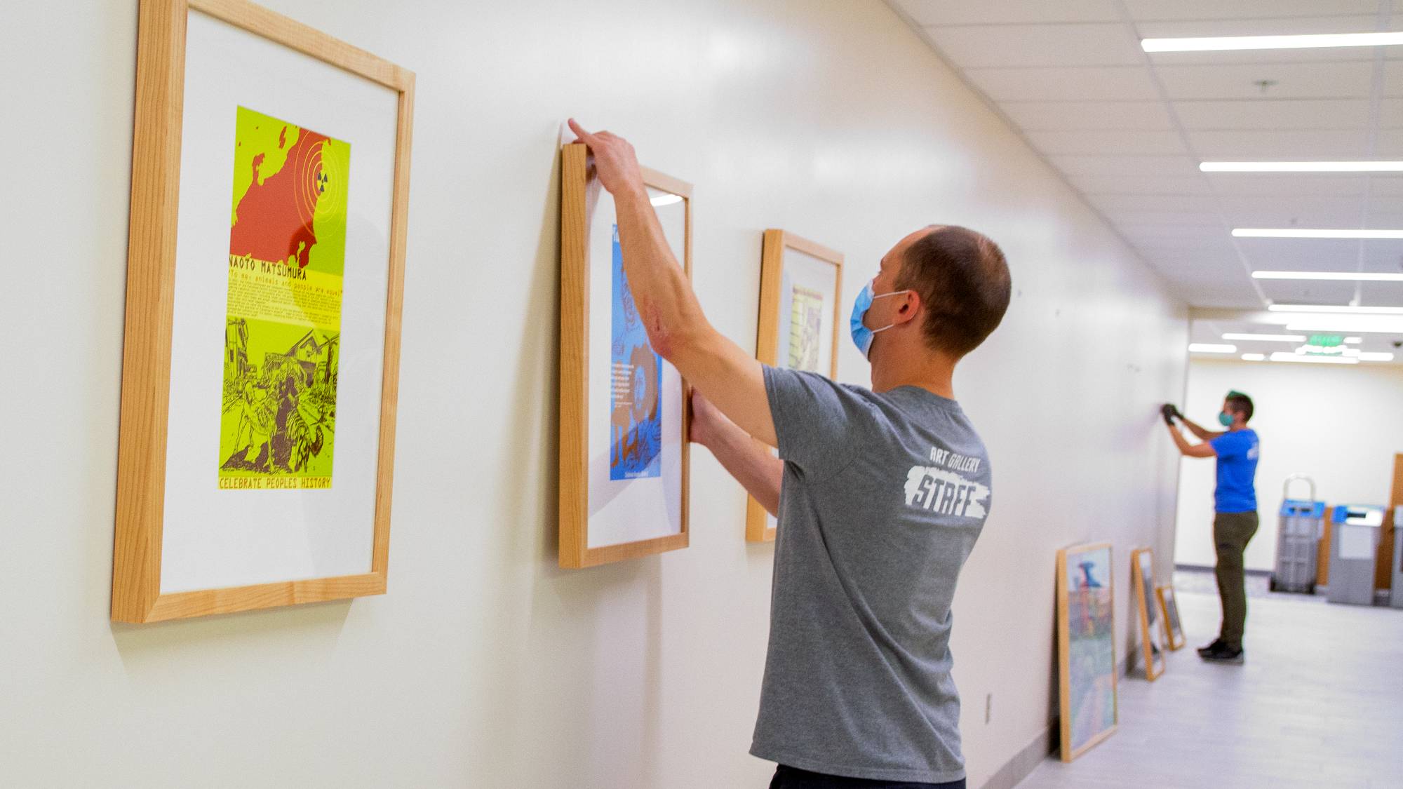 art gallery team installing artwork in hallway
